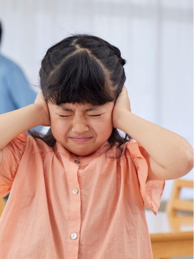 garota tapando os ouvidos com pais atrás