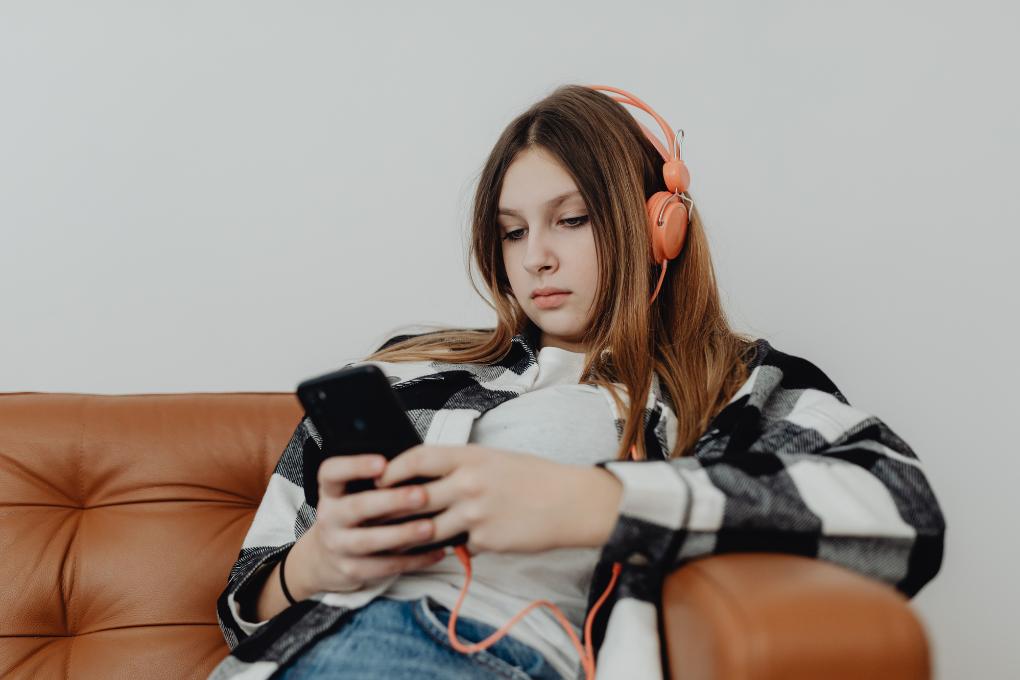 Jovem com fone de ouvido usando o celular