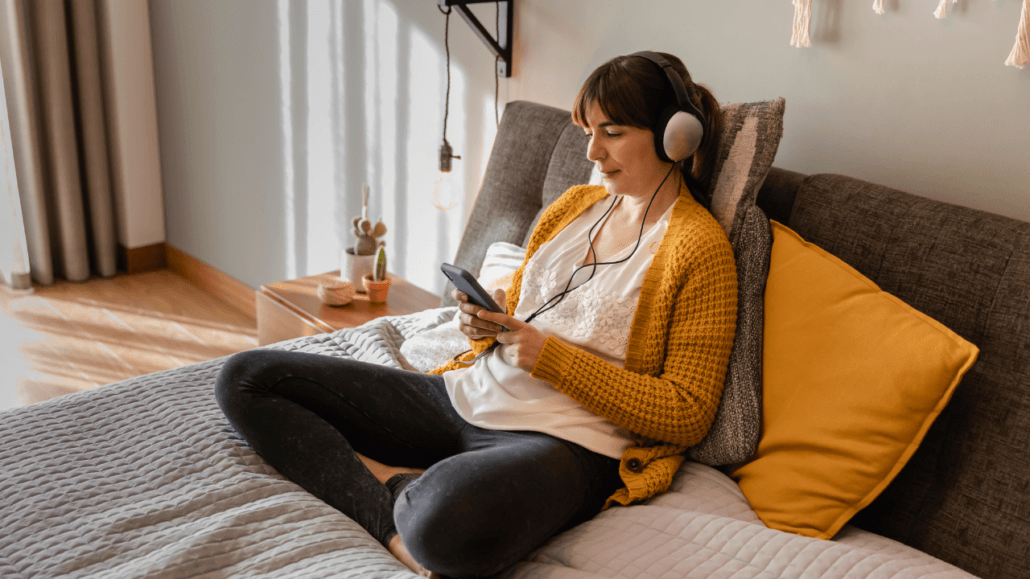 mulher ouvindo musica sentada no sofa