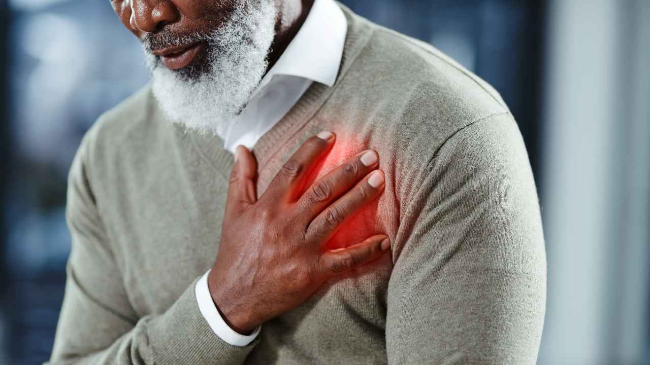 Homem com a mão sobre o peito, destacando dor ou desconforto cardíaco. A imagem pode ilustrar os efeitos do estresse causado pela poluição sonora no bem-estar físico.