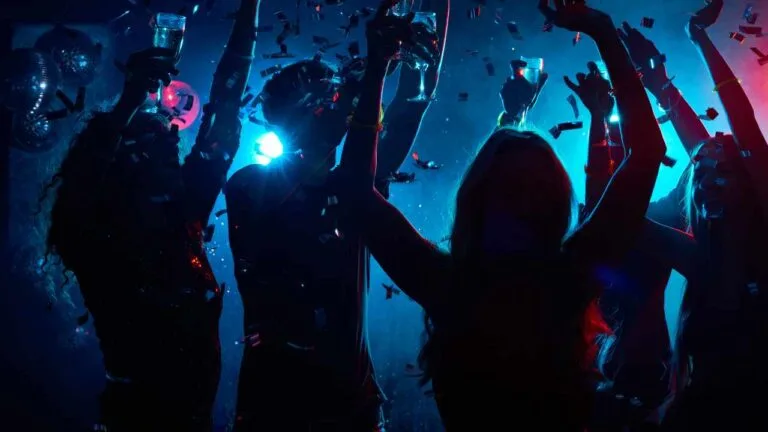 Sombras de pessoas dançando em festa residencial